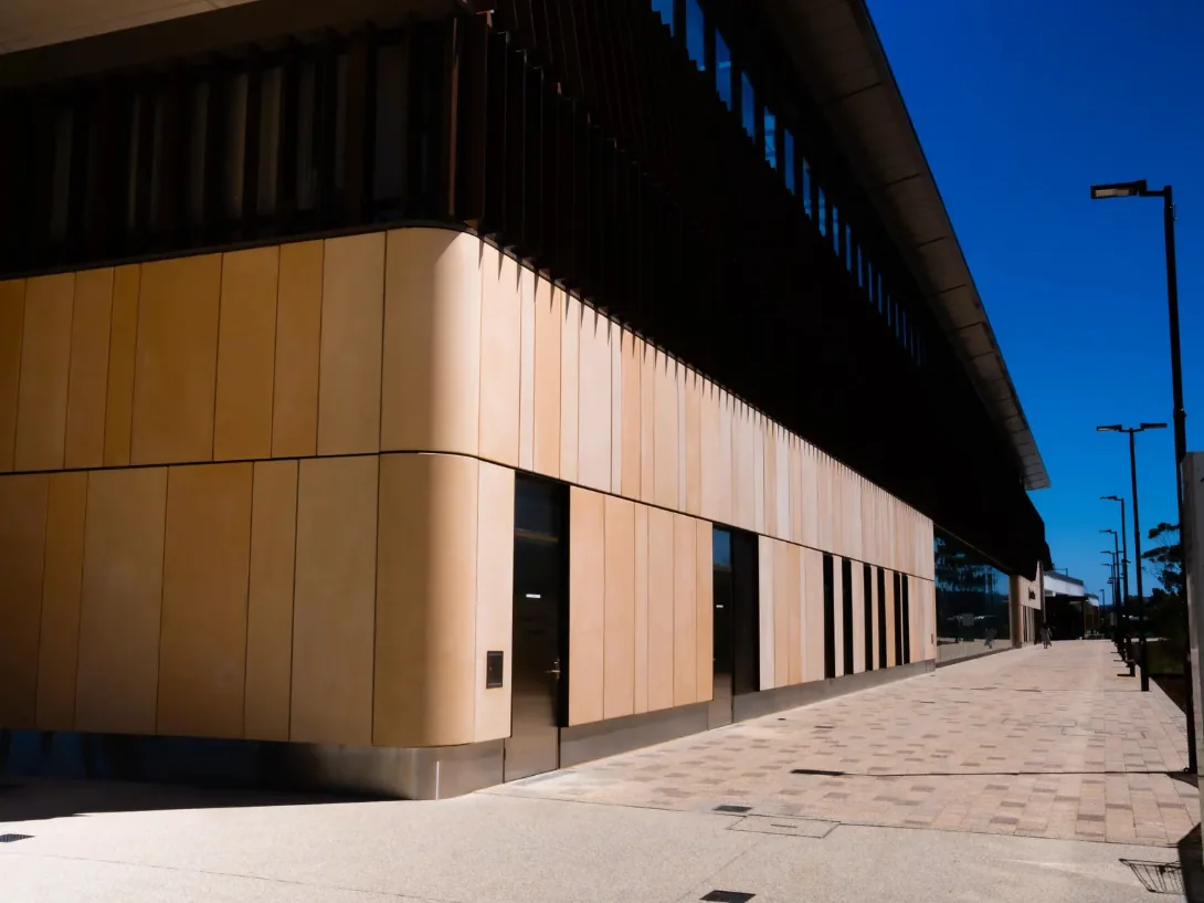 A composite-panel facade meeting a glazed corner