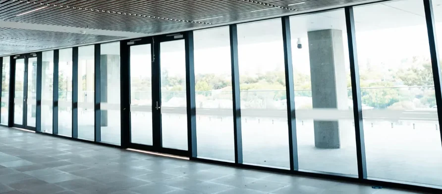 A full-height glazed wall of steel-framed doors opening onto a terrace