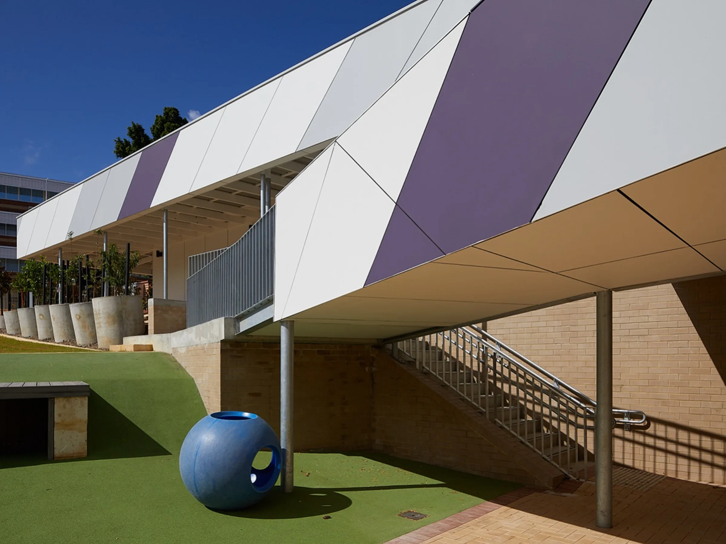 White and purple composite panels folding across a college facade
