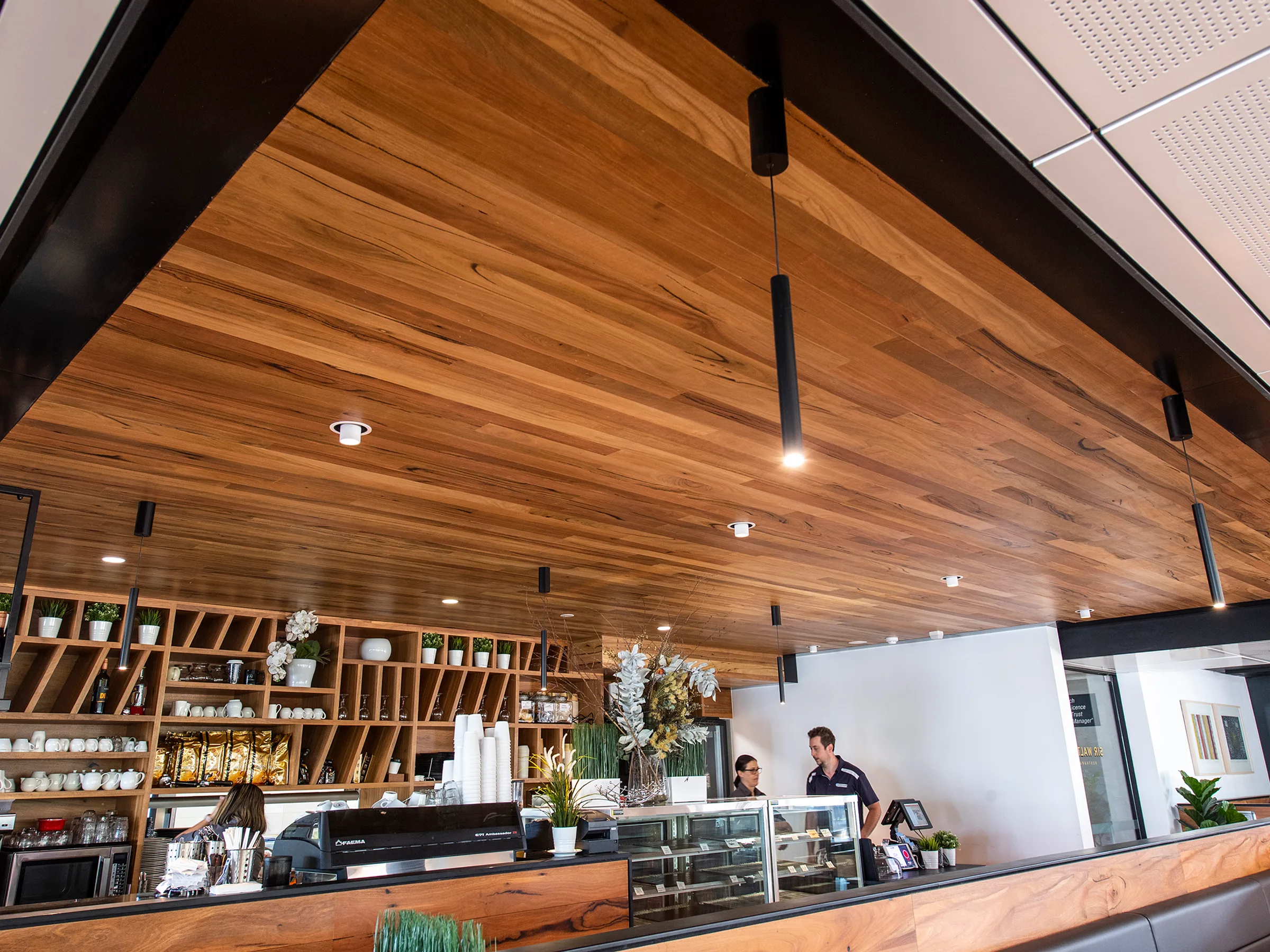 A raked timber ceiling over a restaurant bar and dining room
